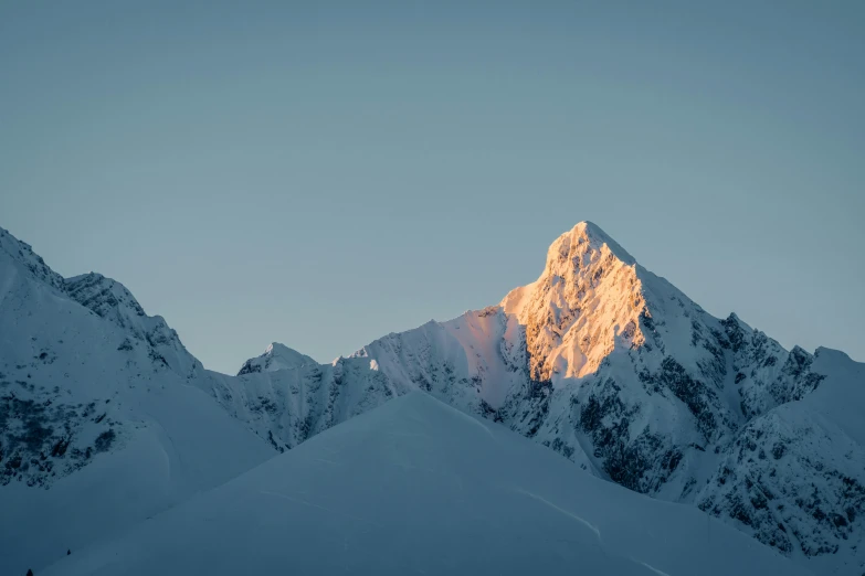 the sun rising over a snowy mountain covered in snow