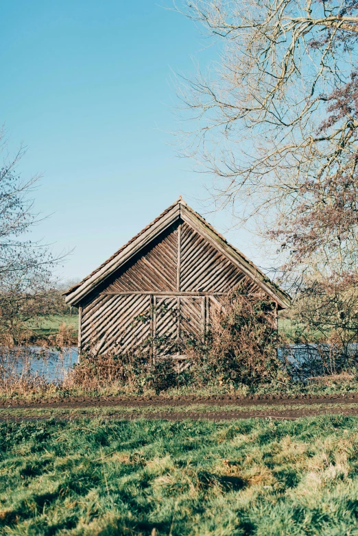 a rustic wooden shed near a stream