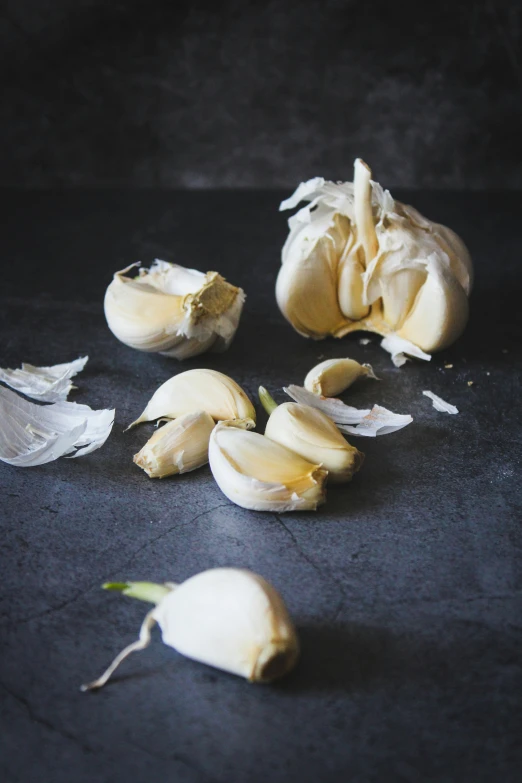 several peeled garlics lay around in a circle on a surface