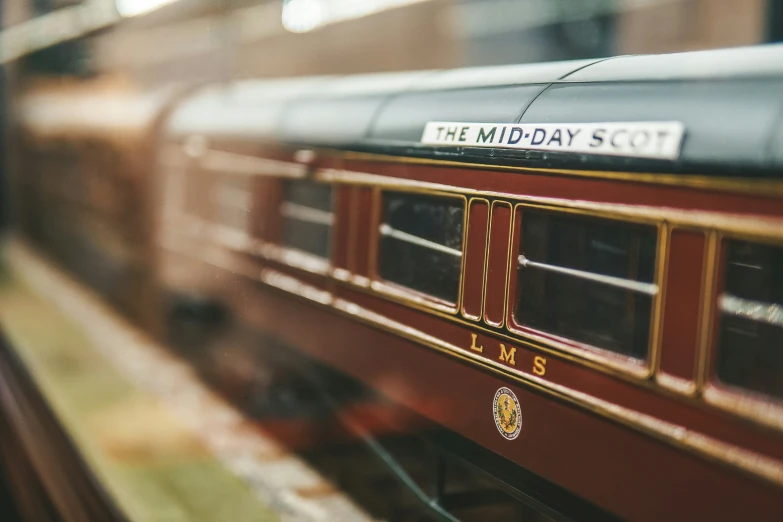 the window of a red train is reflecting its name