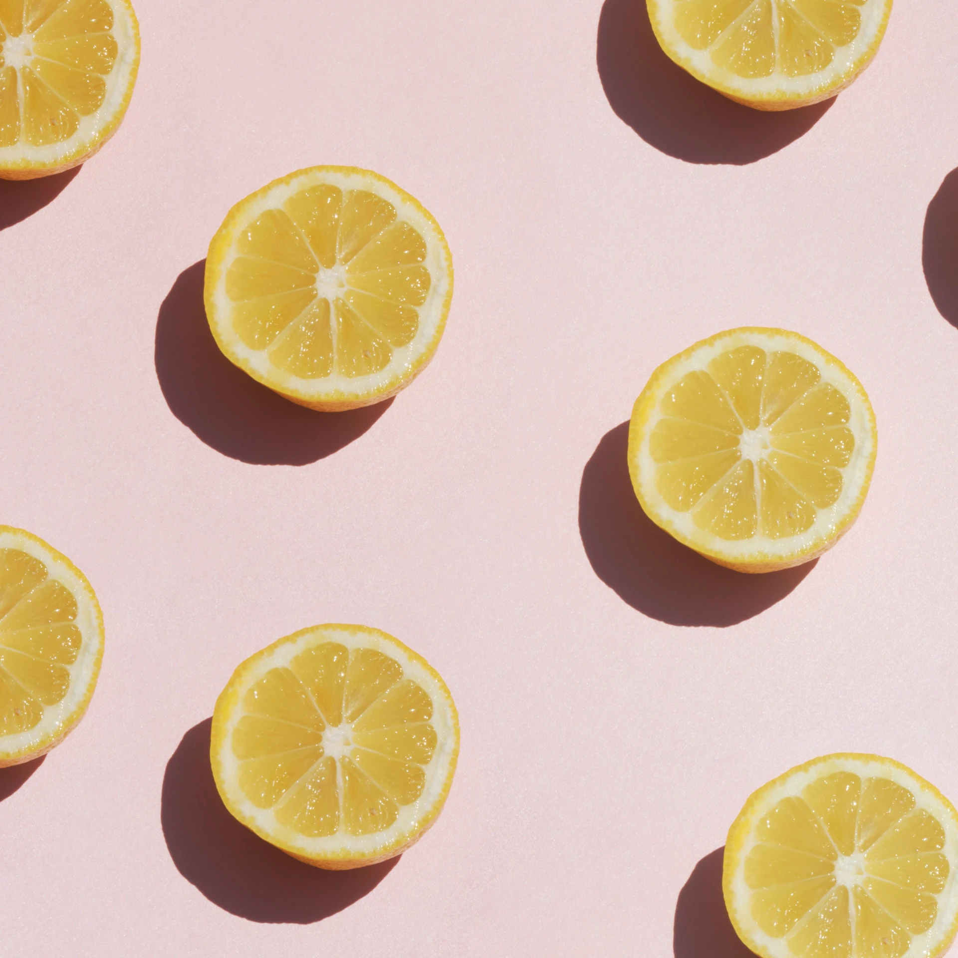 oranges laying on top of each other on pink surface