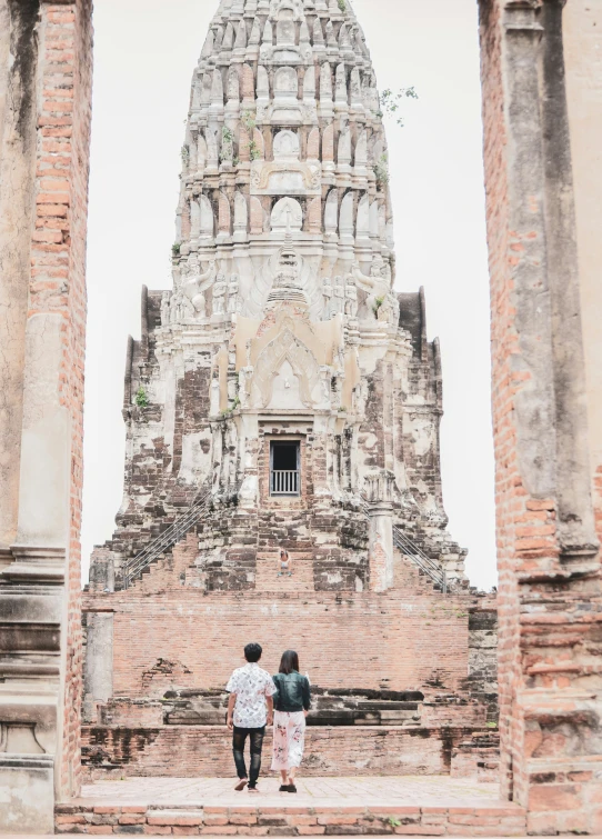 a couple is walking towards the ancient temple