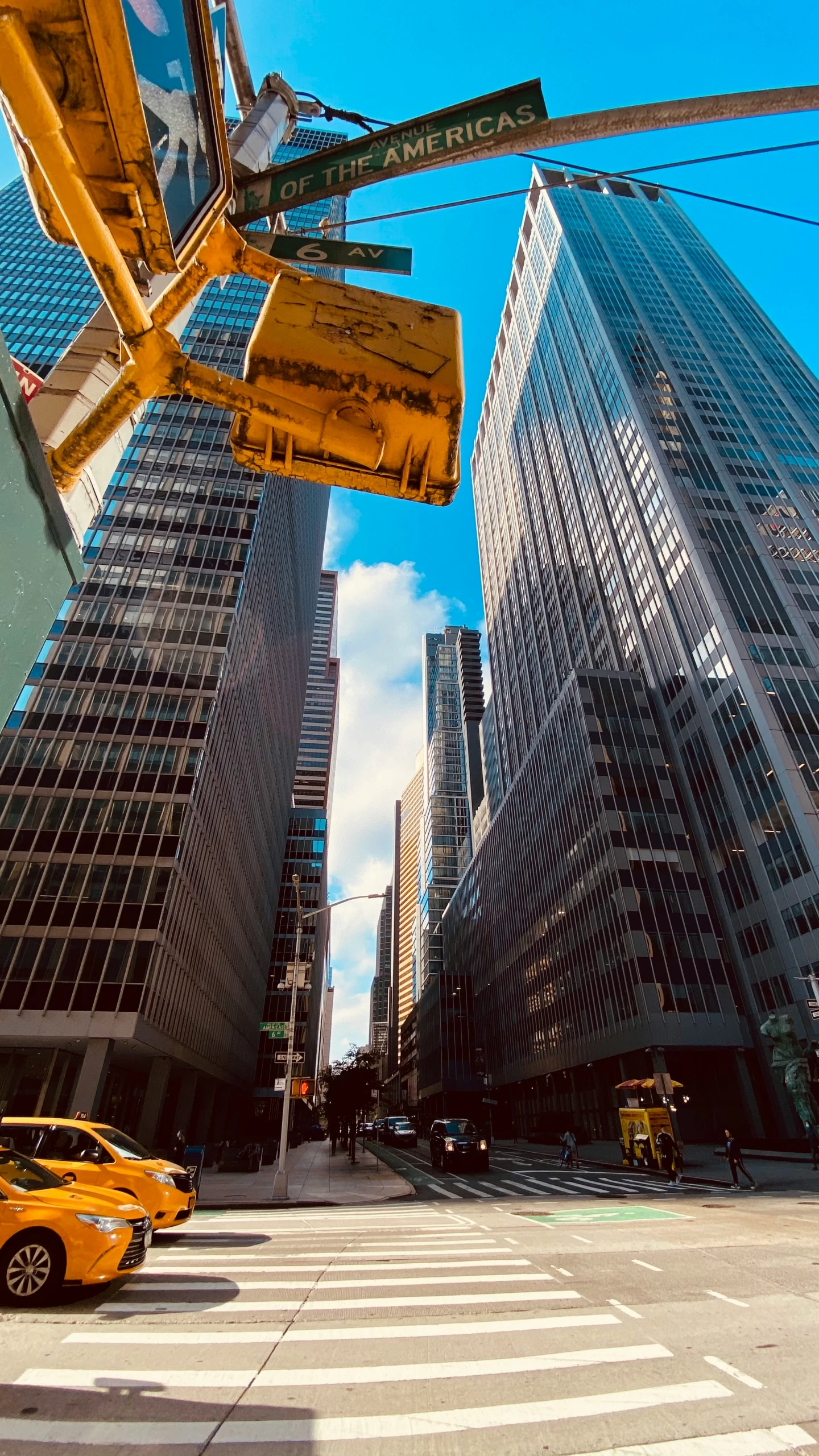 yellow taxis in traffic next to tall buildings