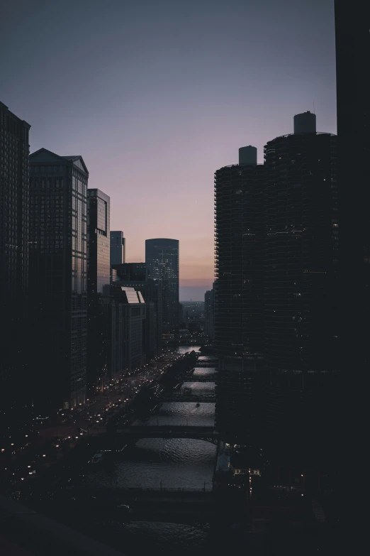 a river is in the middle of some buildings at dusk