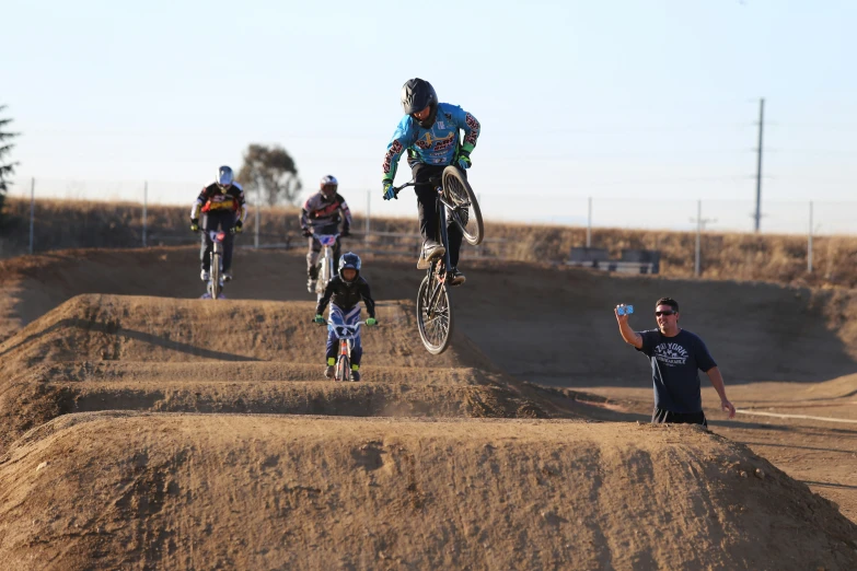 people are on bikes racing and riding down dirt hill