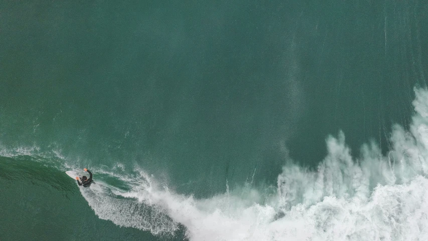 a surfer in the middle of the water, riding a wave