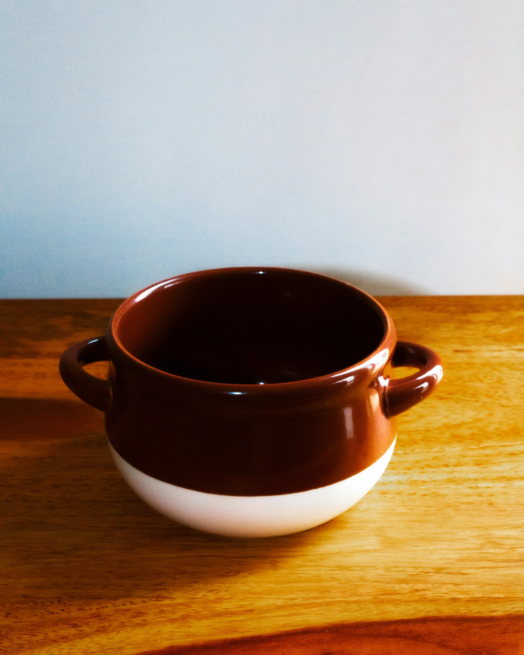 two white and brown pottery dishes on a wood table