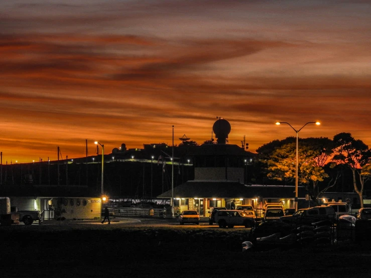 sunset at an industrial area with buildings and cars