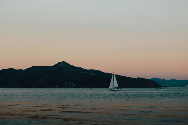 a boat floats in the water with a mountain in the background