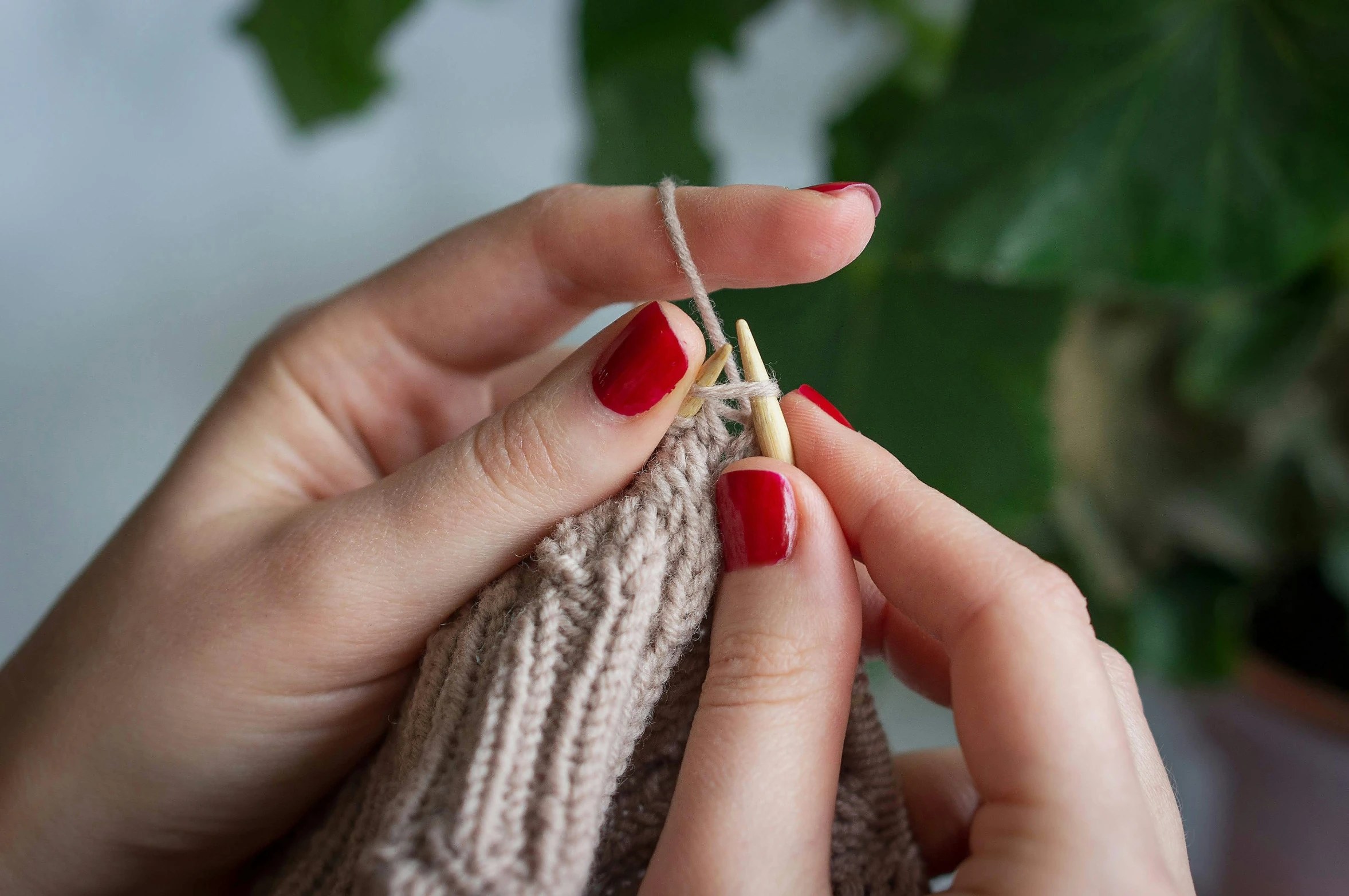 a woman is holding the ends of a thread as she holds one of her fingers up