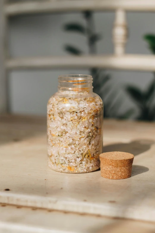 a small jar of bath salts sitting on top of a wooden table