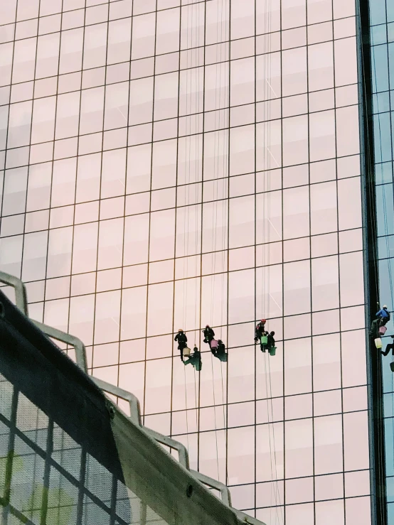 people climbing up a steeple next to a tall building