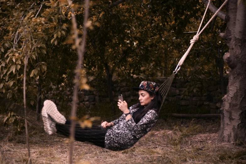 a woman in black and white shirt sitting on hammock