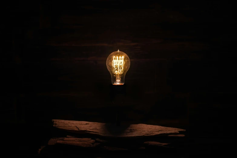 a light bulb on a piece of wood at night