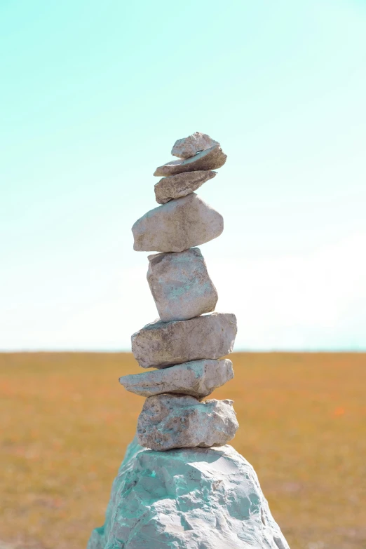 a stack of rocks sitting on top of a lush green field