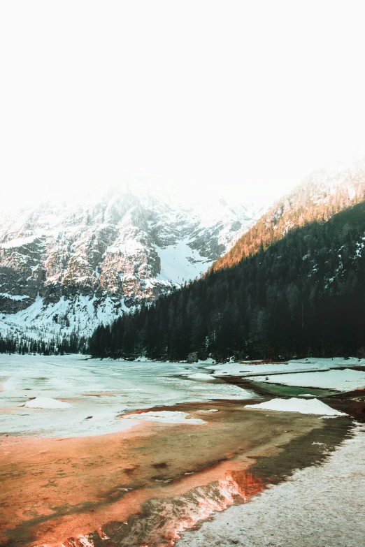 a lake with the mountains covered in snow in the distance