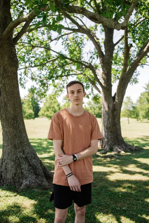 a man standing in front of a big tree