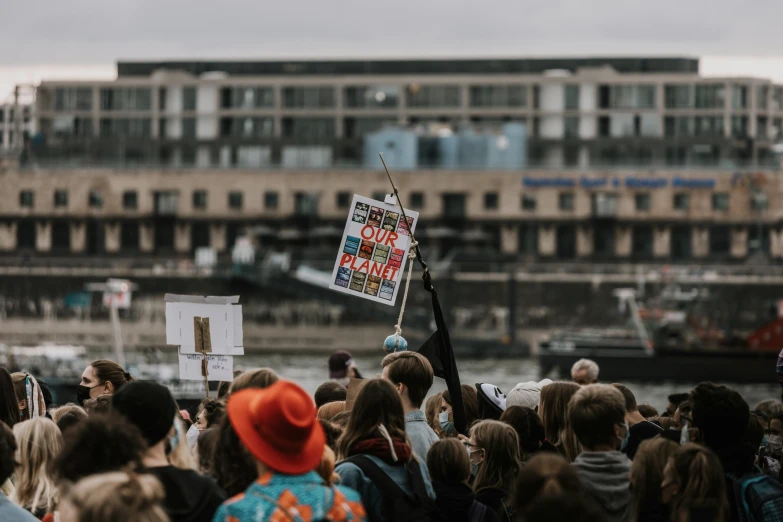 the people are outside at the fair and one is holding up a banner