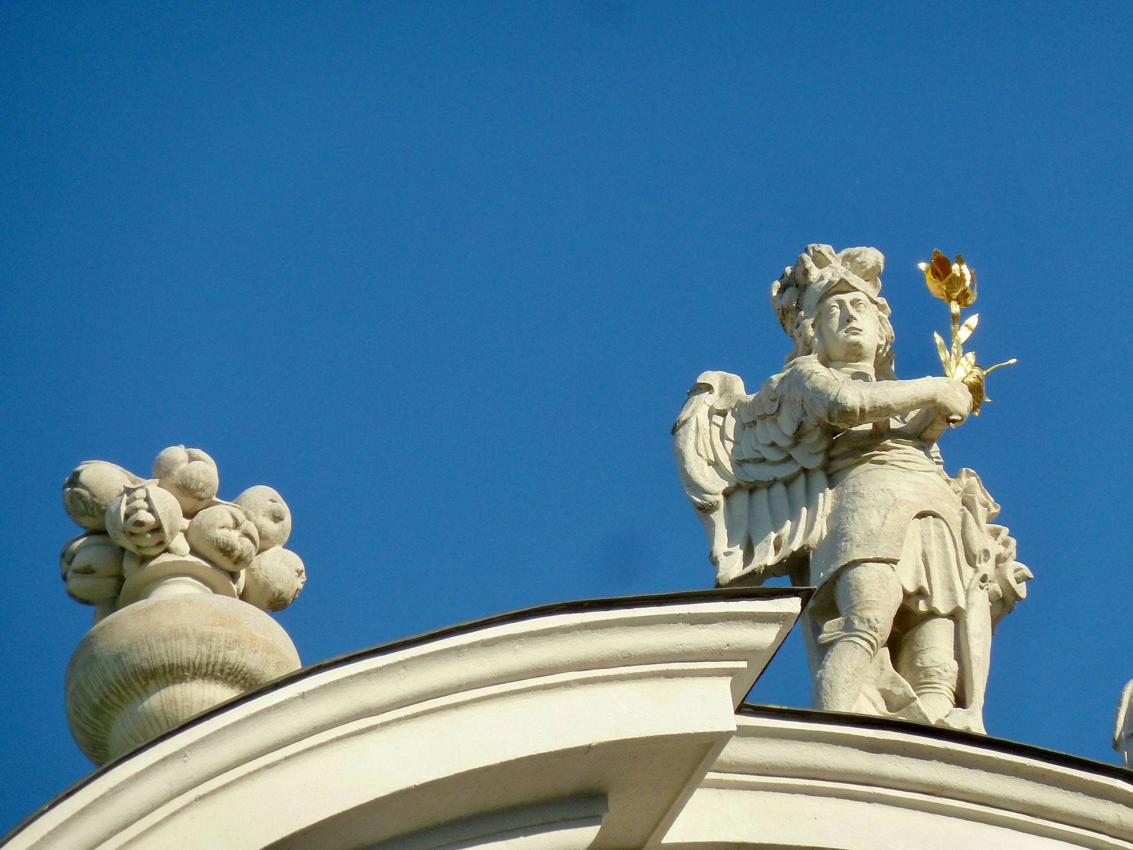 there is a statue on the roof that has an angel and flower