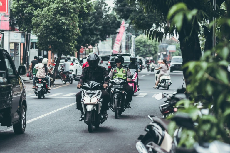 motorcyclists in traffic riding on a city street