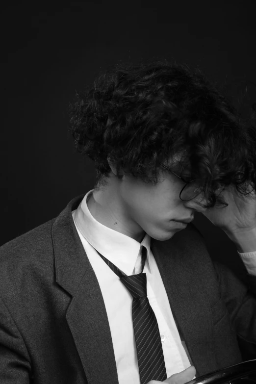 a man wearing a suit and tie touching his hair