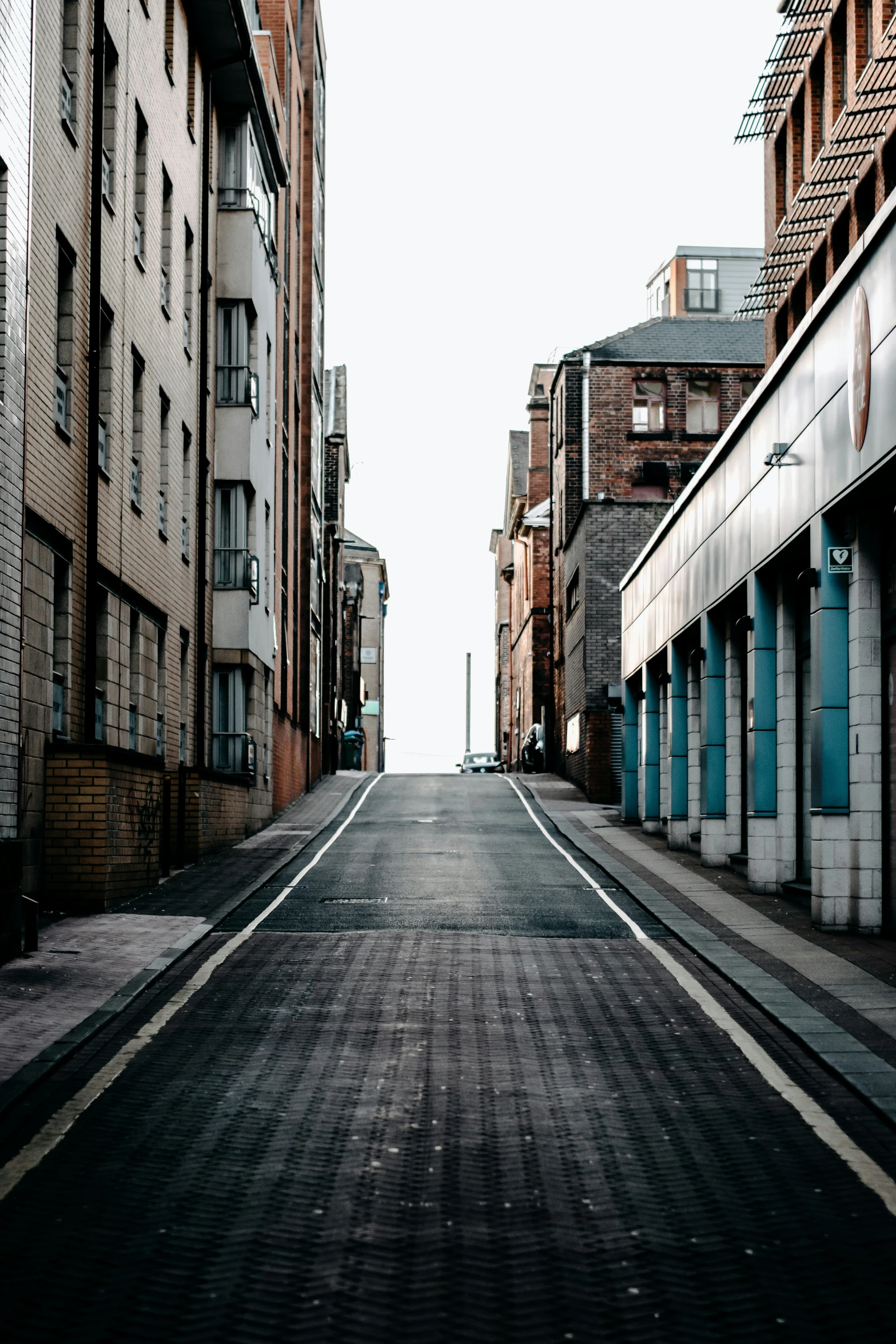 a deserted street is surrounded by brick buildings