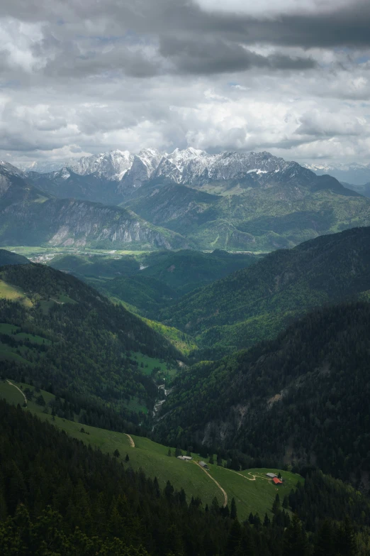 a beautiful, green valley that is on the edge of some mountains