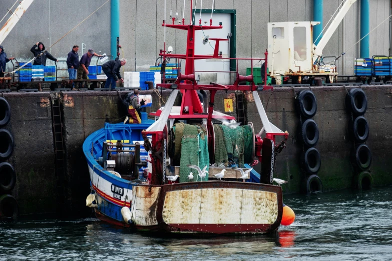 an old fishing boat is docked near a cement dock