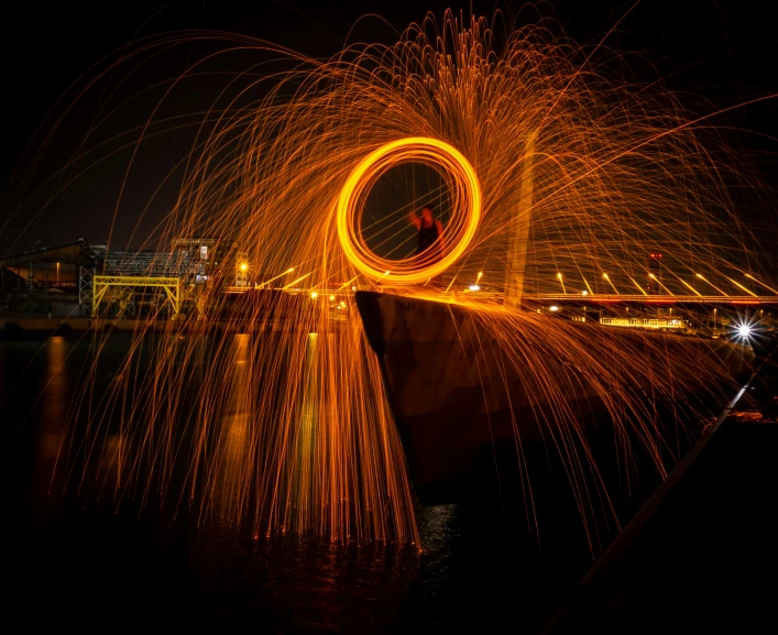 fireworks in the night sky behind an industrial area with lights