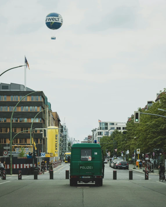 a view of a green delivery truck driving down the street