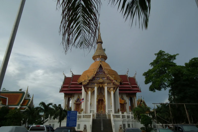 a tall building with a gold roof and tall trees