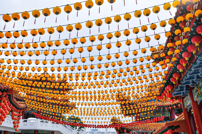 this is the entrance to a park that has orange lantern decorations hanging over it