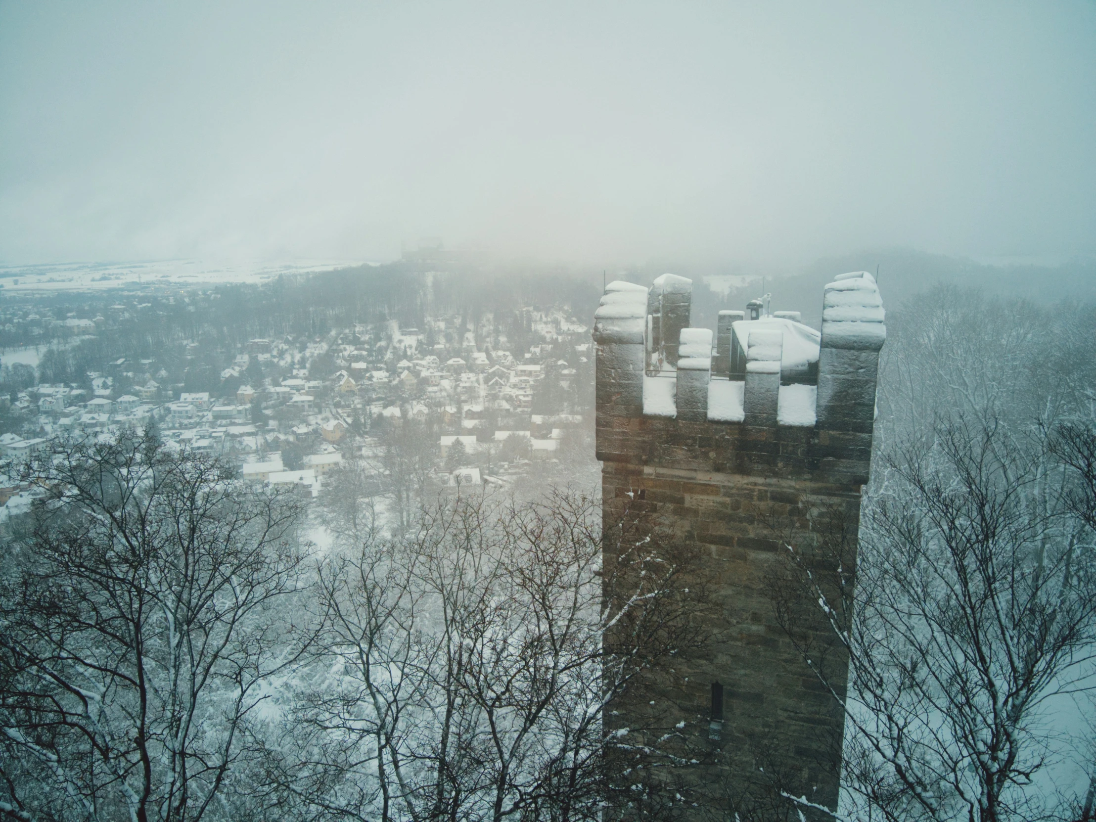 a clock tower with two snow covered buildings in the background