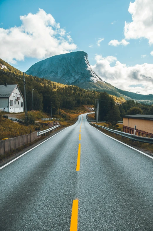 an empty road leading to a beautiful mountain