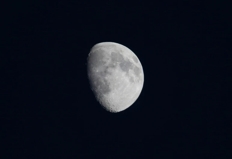 a bright moon seen from afar in the night sky