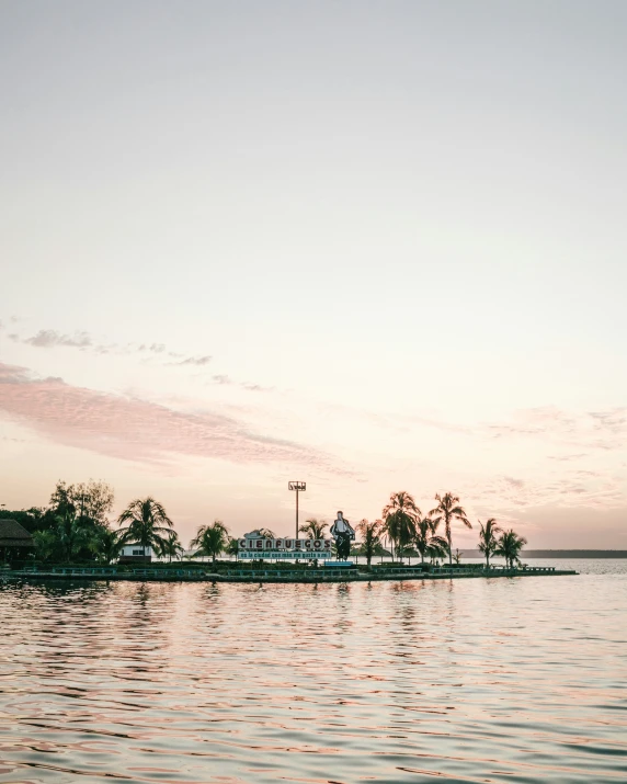 this po is a pink and white sunset over a small island in the ocean