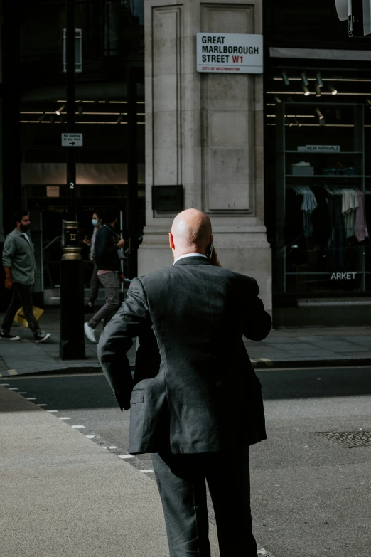 a man is looking at the corner of a city street