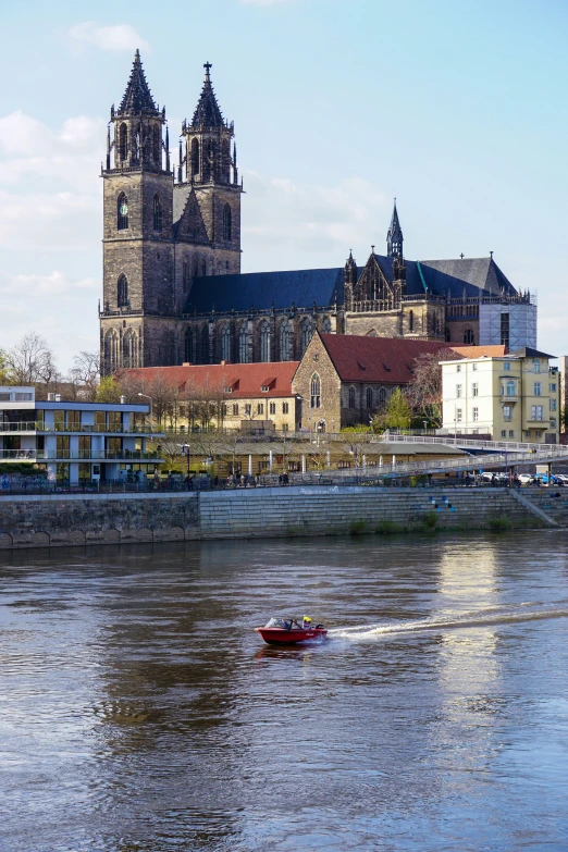 two boats float down the river in front of a very old building