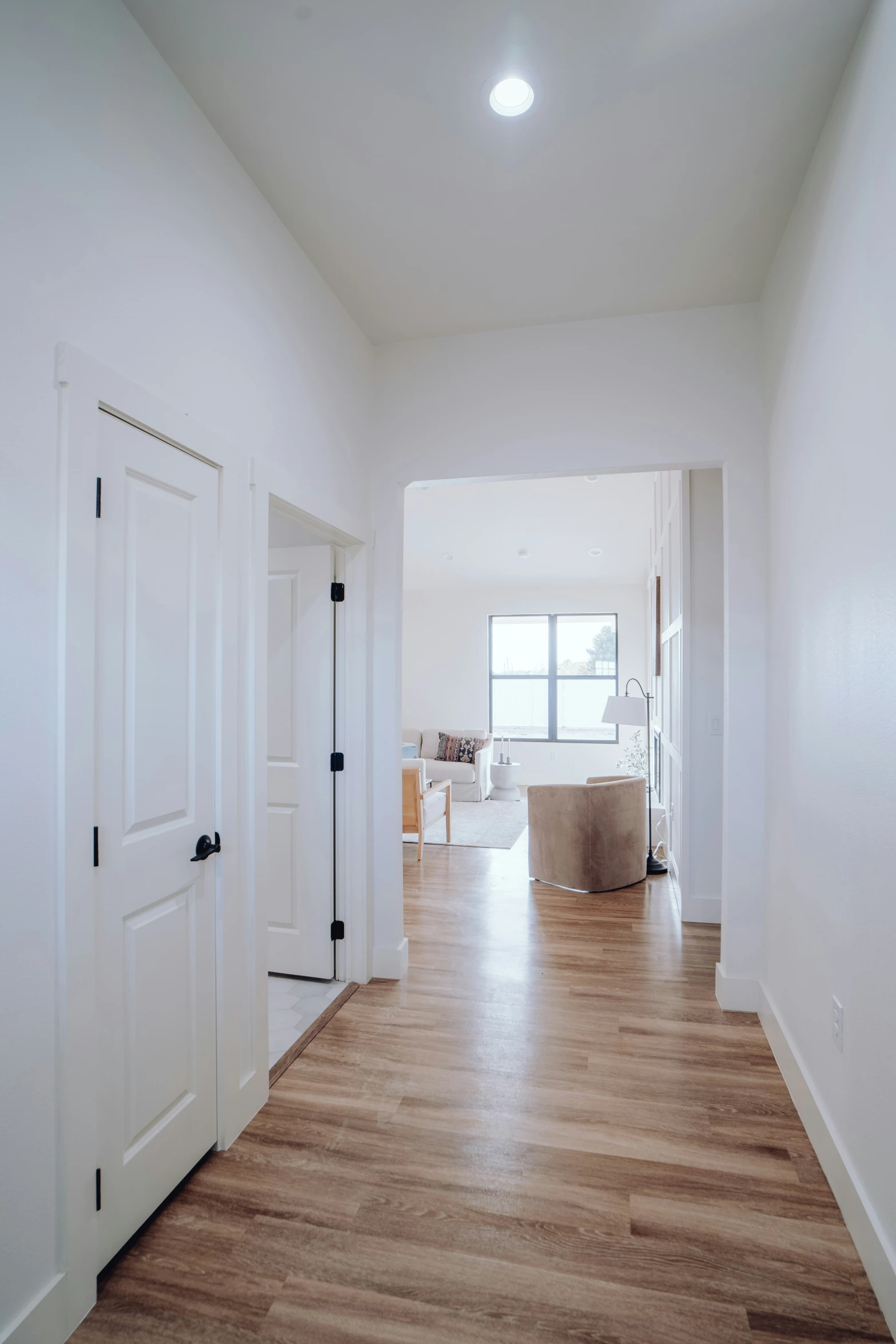 a spacious, empty house with a large wooden floor and wooden doors