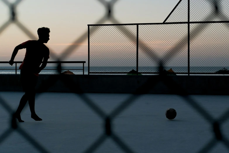 some people on a beach a tennis court and a ball