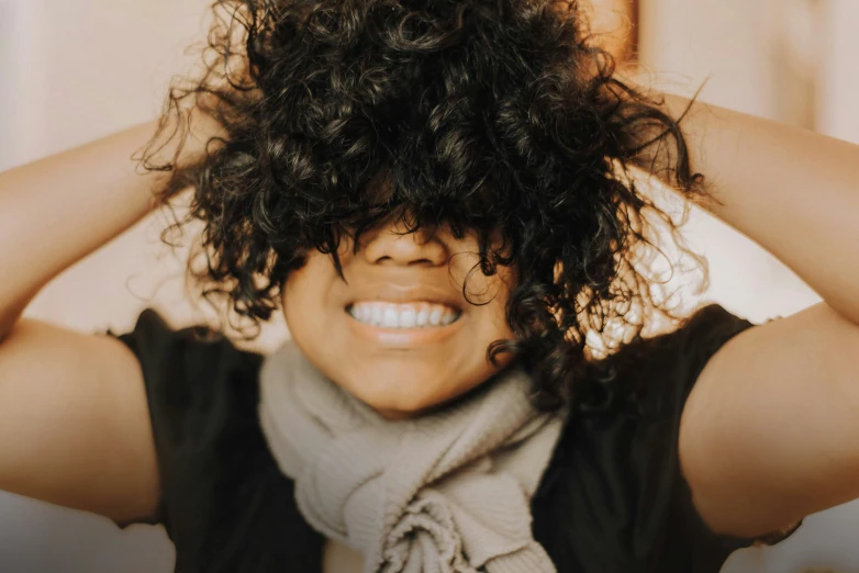 a woman is smiling and putting her hair in the air