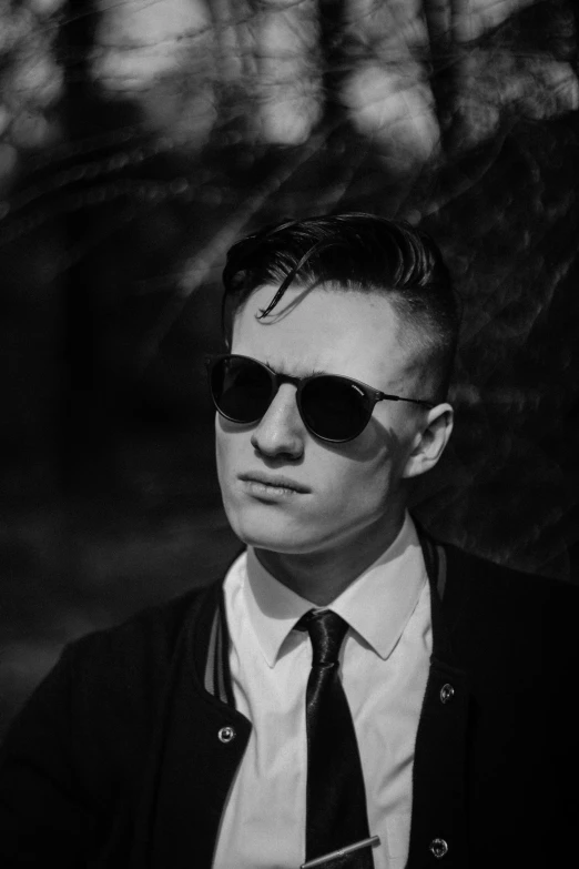 the young man in sunglasses is posing for a black and white po