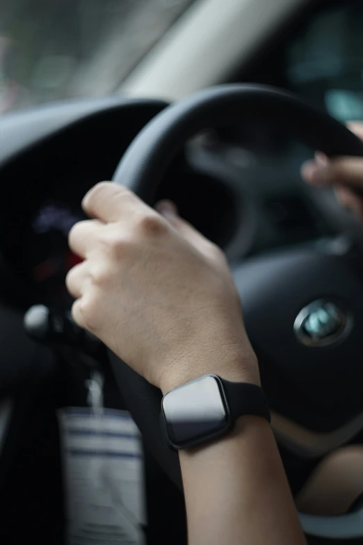 a person is driving while wearing a smartwatch