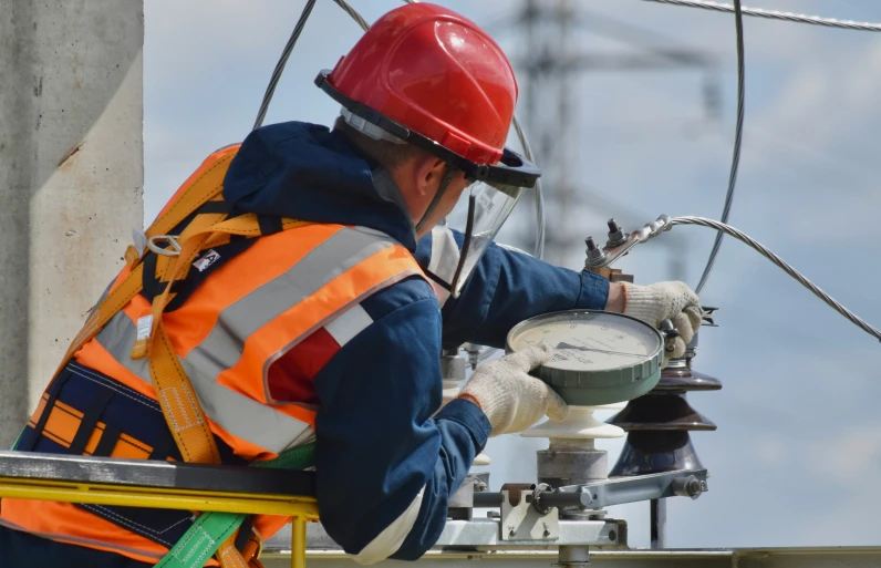 a man working on a device that is mounted on a pole