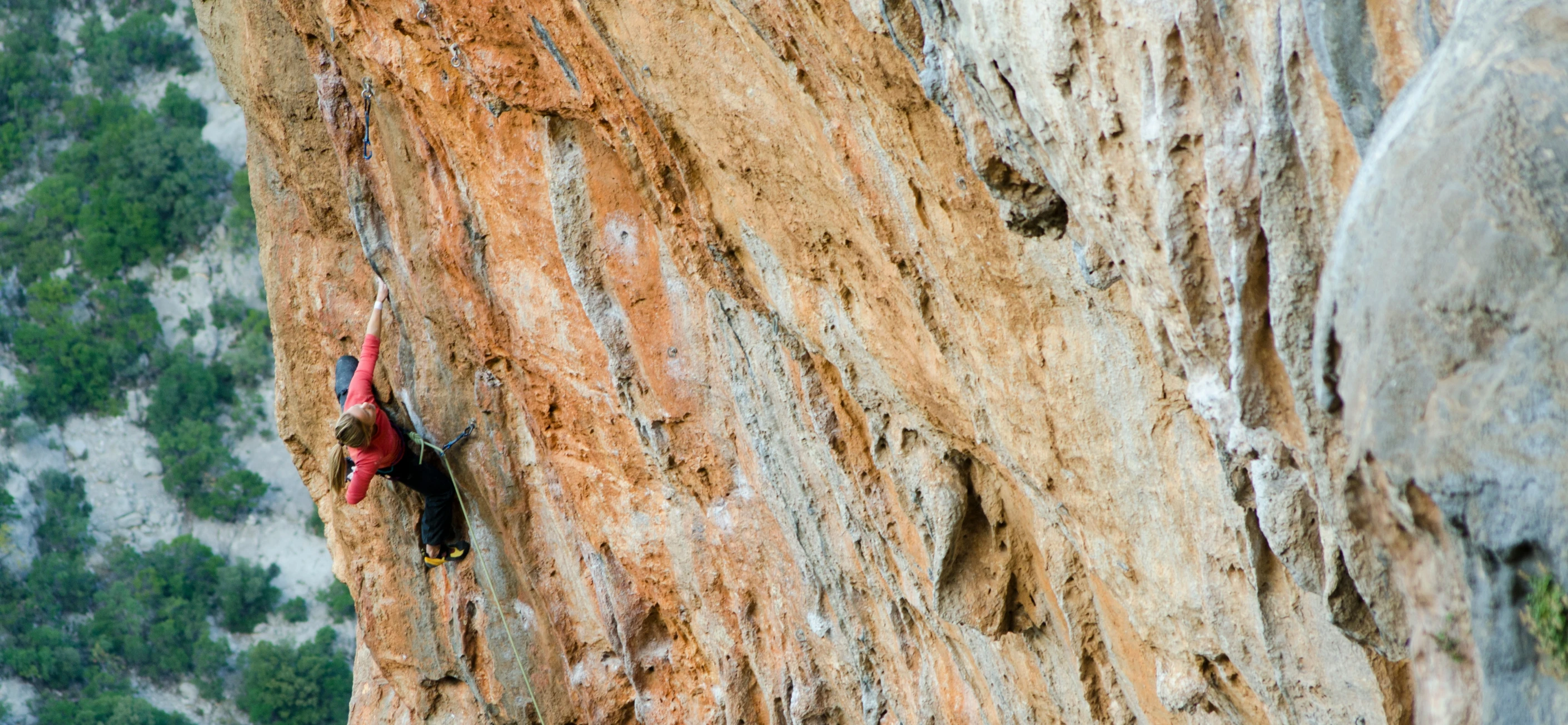 a person on a rope hanging over a cliff side