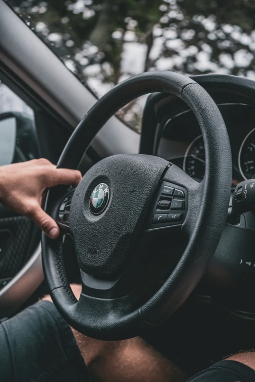 a person's hand on a steering wheel and dashboard of a vehicle