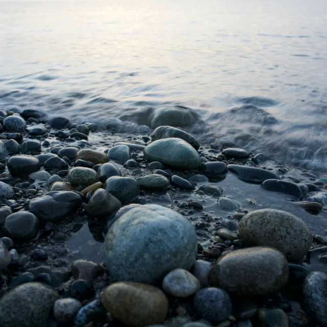 stones and other debris on a beach near the water