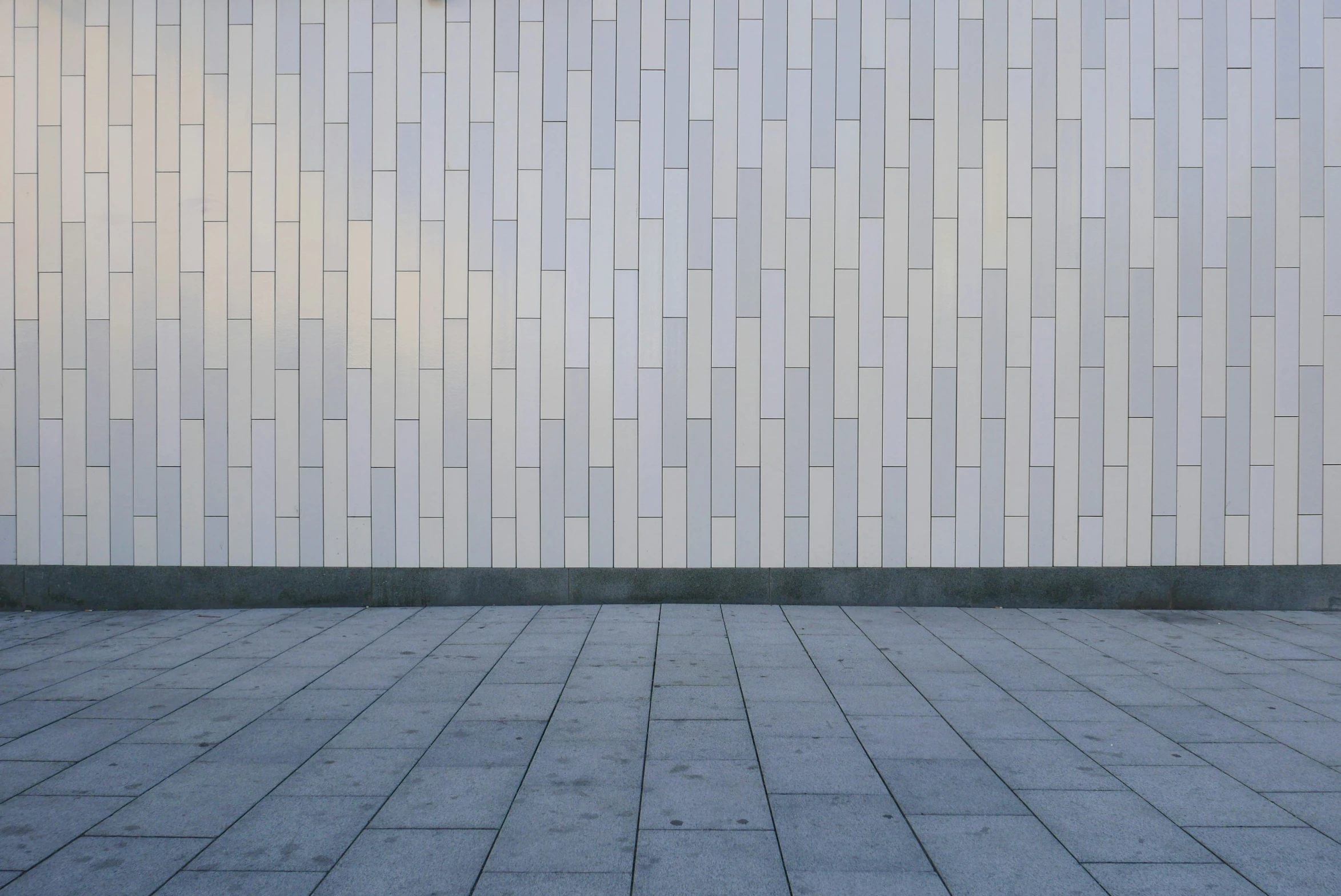 a woman with luggage walks by a wall