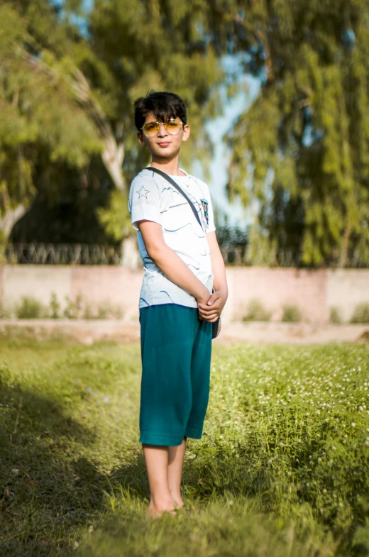 a small boy in sunglasses and blue shorts