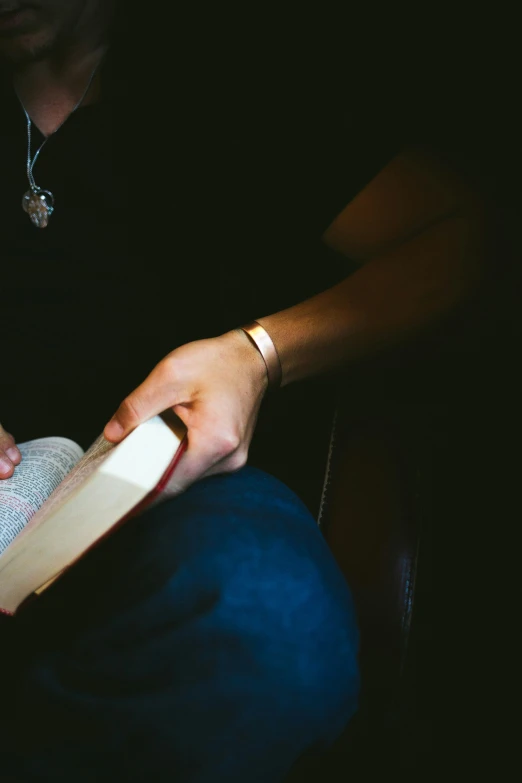 a person holding a book and reading it